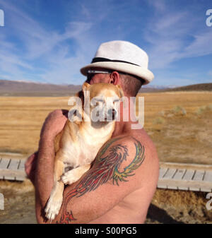 Mann mittleren Alters Holding Terrier-Chihuahua Hund in Owens Valley von Mammoth Lakes, Kalifornien Stockfoto