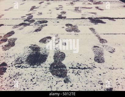 Matschigen Fußabdrücke auf einer Schnee bedeckten Promenade. Stockfoto