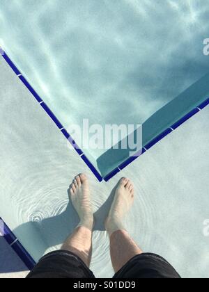 Ein Selbstporträt in einem Schwimmbad. Blickte auf ein Mann Füße stehen in einem Pool in Florida, USA. Stockfoto