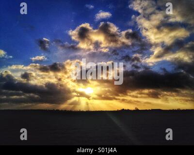 Dramatischer Himmel, Wellen, wenn die Sonne hinter Wolken Stockfoto