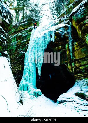 Gefrorenen Wasserfall mit Eiskletterer an Spitze. Ausgehungert Rock State Park (Illinois) Stockfoto