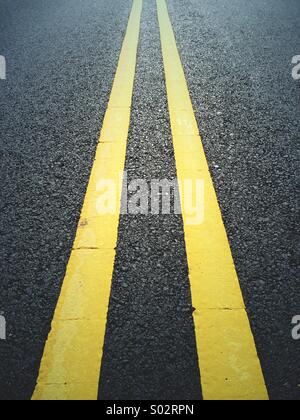 Doppelte gelbe Linien auf schwarzem Asphalt/Asphalt Straße in New Jersey, USA. Stockfoto