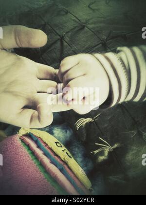 Kindheit, Babys Hand festhalten an Teenager Hand, Retro-filter Stockfoto