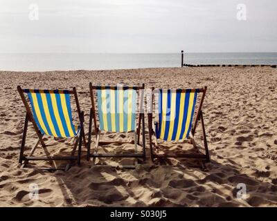 Drei Liegestühle auf Bournemouth West Beach, mit Blick auf das Meer, warten auf Urlauber. Großbritannien Stockfoto