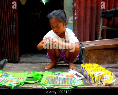 Junge asiatische Mädchen verkaufen Bonbons in Quiapo, Manila, Philippinen in Asien Stockfoto