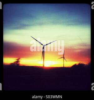 Windenergieanlagen bei Sonnenuntergang Stockfoto