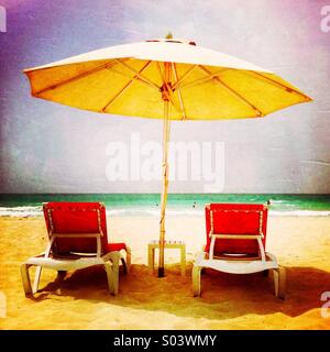 Zwei Stühlen unter einem Sonnenschirm am Strand. Abu Dhabi. Vereinigte Arabische Emirate. Stockfoto