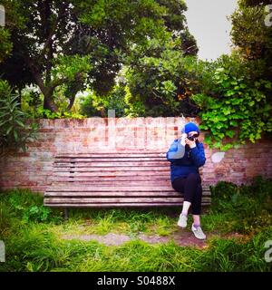 Eine junge Frau sitzt auf einer Bank-Bank ein Foto. Venedig Italien Stockfoto