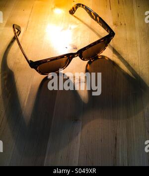 Fotos auf Schreibtisch im Sommersonne wirft lange Schatten Stockfoto