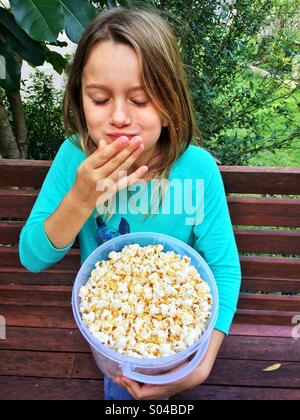 Junges Mädchen essen popcorn Stockfoto