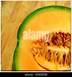 Frische und saftige Melone Melone in Scheiben geschnitten in die Hälfte und zeigt Samen Fleisch und Haut Stockfoto