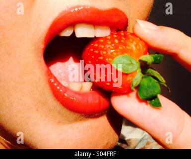 Erdbeere, zwischen roten Lippen gebissen Stockfoto