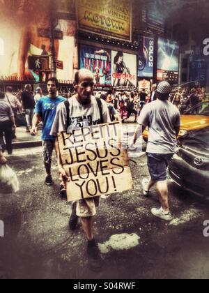 Mann mit einem Schild, das liest "Buße Jesus Loves You" in Times Square, New York City Stockfoto