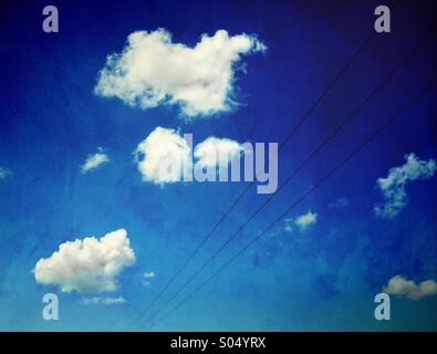 Pylon Drähte und weiße Wolken gegen blauen Himmel Stockfoto