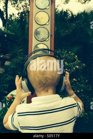 Kleiner Junge mit Kopfhörern Musik hören Stockfoto