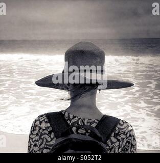 Eine Frau schaut brechen Wellen und die ankommenden Brandung. Stockfoto