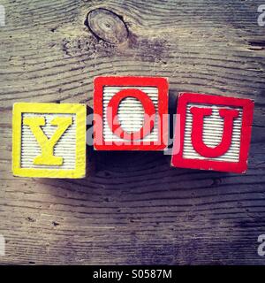 Es ist ein Foto von drei Holz Würfel Aith Briefe, die von einem Kind das Wort erstellen nebeneinander gesetzt worden: SIE Stockfoto