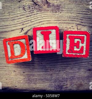 Es ist ein Foto von 3 Holz Würfel Spielzeug mit Buchstaben, die das Wort sterben zu bilden Stockfoto