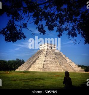 Eine Frau geht vor dem Tempel der Kukulkan in der Maya-Stadt Chichen Itza, Yucatan, Mexiko Stockfoto