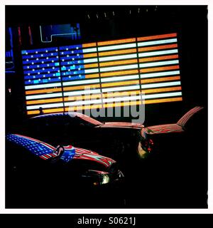 US-Flagge auf dem Times Square spiegelt sich im Verkehr Stockfoto