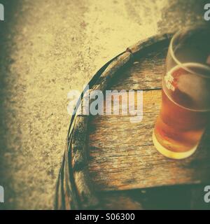 Bierglas auf alten Holzfass Stockfoto