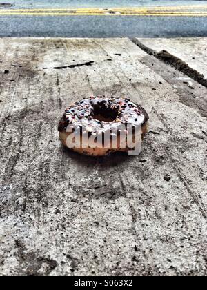 Schokolade überdachten Donut auf Bürgersteig Stockfoto