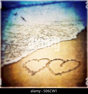 Liebe am Strand, zwei Herzen In den Sand gezeichnet Stockfoto