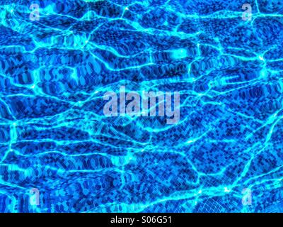 Wasser plätschert und verzerrt blaue Mosaike Fliesen in einem Schwimmbad. Bildnachweis - © COLIN HOSKINS. Stockfoto