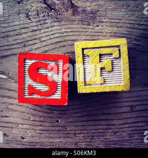 Es ist ein Foto der Holzschnitte Spielzeug wird Alphabet Buchstaben auf ihnen, die kombiniert zusammen, um die Abkürzung SF sind Stockfoto