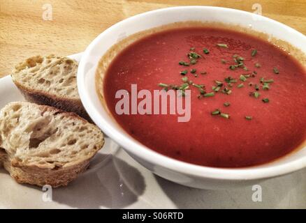 Tomaten-Basilikum-Suppe in eine Schüssel mit Brot auf der Seite Stockfoto