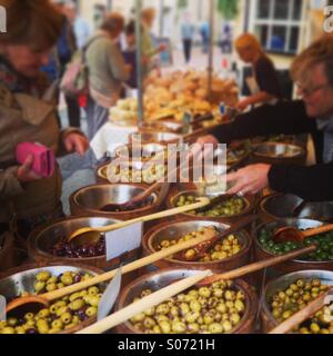 Oliven kaufen auf dem Stroud Farmers Market, Gloucestershire, Großbritannien. Foto des iPhone-Mobiltelefons im Instagram-Stil. Stockfoto