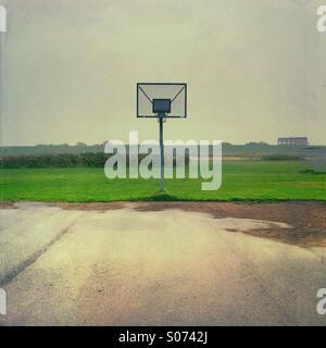 Leere nasse Basketballplatz an einem grauen Regentag in der Nähe von Husum, Nordfriesland, Schleswig-Holstein, Deutschland Stockfoto