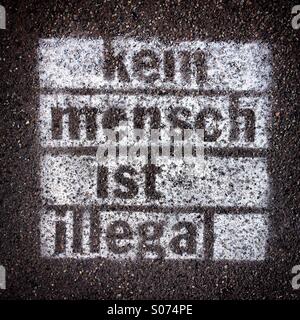 Graffiti auf Bürgersteig mit Worten lackiert "Kein Mensch ist Illegal" in deutscher Sprache (kein Mensch ist Illegal) Stockfoto