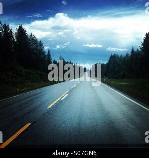 Eine lange gerade Straße im Norden Finnlands in der Nähe der Polarkreis Überschrift für einen typischen Sommer-Abend-Sturm Stockfoto