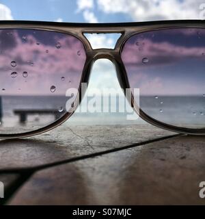 Das Meer durch Regen durchnässt Sonnenbrillen Stockfoto