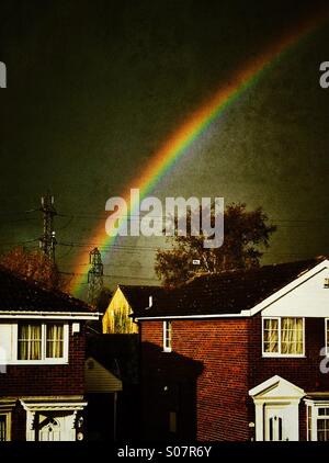 Regenbogen über Dächer an einem stürmischen Tag England UK Stockfoto