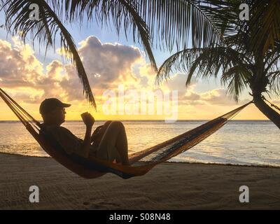 Menschen trinken Kaffee am Strand in der Hängematte, Karibik, Belize Stockfoto