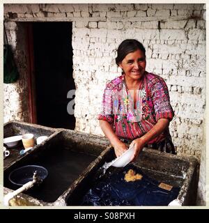 Eine indigene Maya-Frau wäscht ein Gericht in Pila (guatemaltekische Waschbecken) in Guatemala. Stockfoto