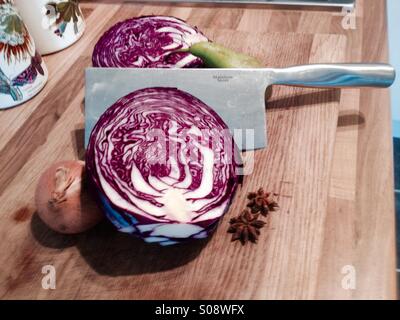 Rotkohl und Sternanis auf hölzernen Schneidebrett mit scharfen Messer Stockfoto