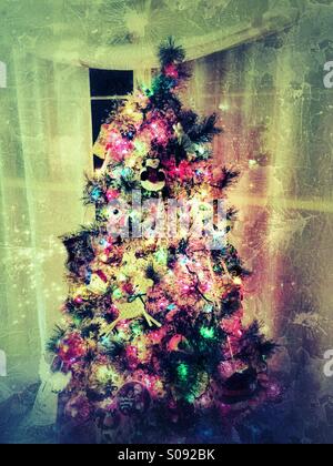 Bunte trashigen Weihnachtsbaum mit hellen Lichtern und Ornamente im Wohnzimmer während der Ferienzeit Stockfoto