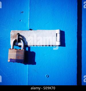 Ein Vorhängeschloss auf einer blauen Tür. Stockfoto