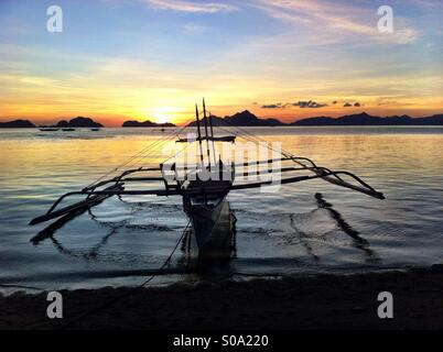 Silhouette der traditionellen philippinischen Bangka Fischerboot in El Nido auf der Insel Palawan mit tausend Inseln bei Sonnenuntergang Stockfoto