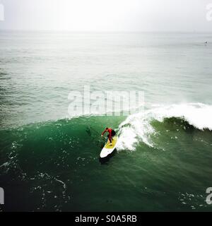 Stand up Surfer surft auf eine Welle. Manhattan Beach, Kalifornien USA. Stockfoto