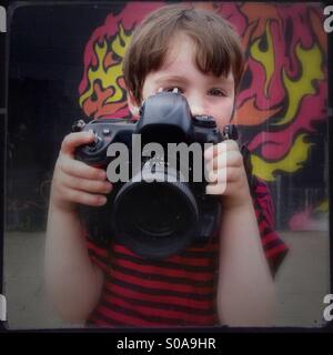 Kleiner Junge mit großen Kamera. Ein fünf Jahre alter Junge mit einer vollständigen Größe slr. Stockfoto