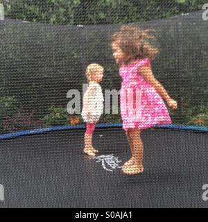 Zwei kleine Mädchen springt auf einem Trampolin. Stockfoto