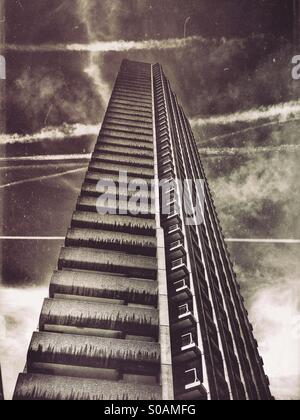 Schwarz / weiß Foto von Shakespeare Turm gegen einen Himmel gesprenkelt mit Wolkenfetzen und Ebene Strecken im Barbican, London, England. Stockfoto