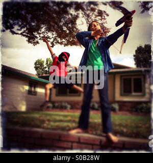 Ein sechs Jahre alter Junge und seine elfjährige Schwester bekommen in den Charakter ihrer Halloween-Kostüme. Stockfoto