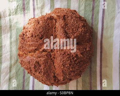 Frisch hausgemachte Brot Natron Kühlung auf ein grün und braun gestreiften Geschirrtuch. Stockfoto