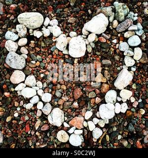 Ein weißes Herz aus Stein aus farbigen Kieselsteinen am Strand gemacht Stockfoto