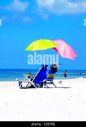 Paar von bunten Sonnenschirmen Stuhl unter dem lauen blauen Himmel Stockfoto